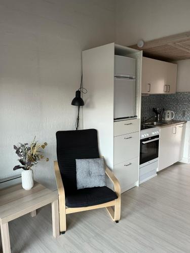 a kitchen with a chair and a table and a counter at Feriepark Langeland Ristinge (Feriepark Langeland) in Humble