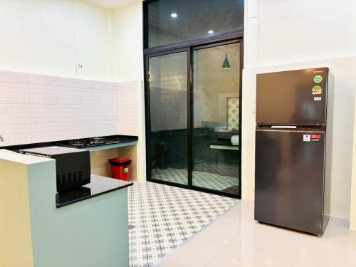 a kitchen with a stainless steel refrigerator in a kitchen at Dee Tee homestay hatyai in Ban Kohong