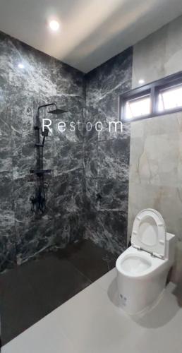 un baño con aseo y un letrero en la pared en Top Ayutthaya Home of peace the sound of birds, en Ban Phlap