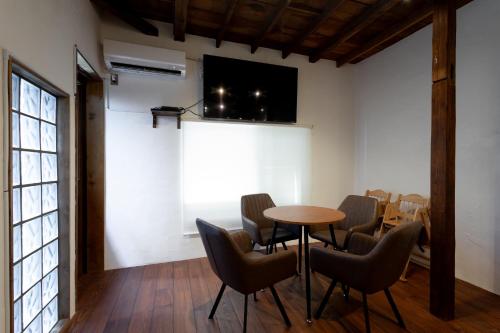 a room with a table and chairs and a tv at ナカノコミチ Nakanokomichi in Tokyo