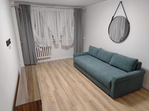 a living room with a blue couch and a mirror at Łokietka 13 Zielony Parter in Inowrocław