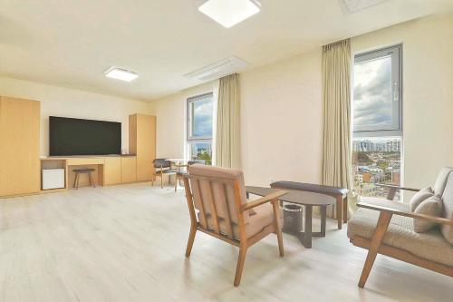 a living room with a flat screen tv and a couch at Berith Hotel in Sokcho