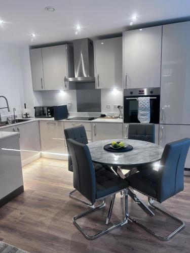 a kitchen with a table and chairs in a kitchen at The Ivy Abode 2 bedroom ApartmentParking in Harlow