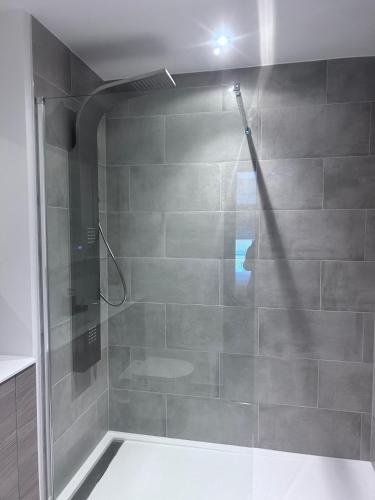 a shower with a glass door in a bathroom at The Sunrise Den-Lovely 2 bedroom apartmentParking in Harlow