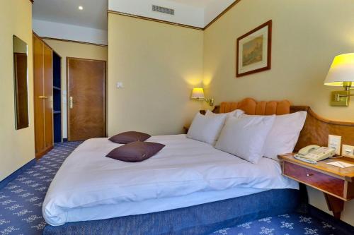 a hotel room with a large bed and a telephone at Hotel Mirabeau, BW Signature Collection, Lausanne in Lausanne
