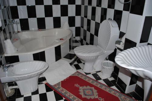 a bathroom with a tub and a toilet and a sink at Riad Villa Midelt in Midelt