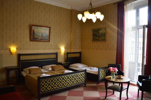 a bedroom with two beds and a table at Hotel Pension Bella in Berlin