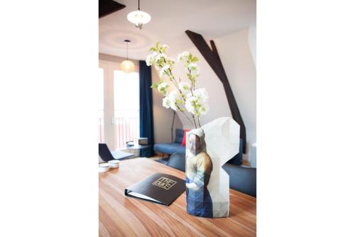 a living room with a table with a vase of flowers at The Duke Boutique Apartments in Den Bosch