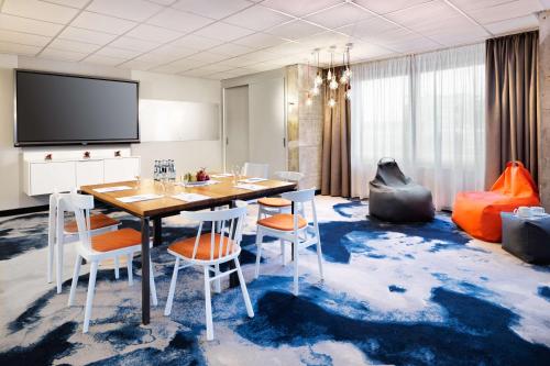 a dining room with a table and chairs on a blue carpet at Best Western Hotel Das Donners in Cuxhaven