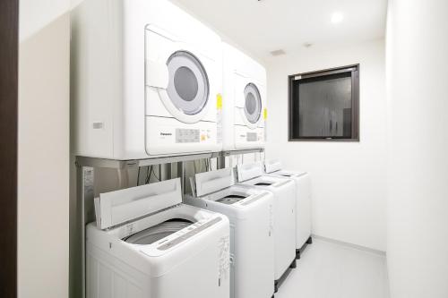 a row of washers and dryers in a laundry room at Randor Residence Kyoto Nijo Castle in Kyoto
