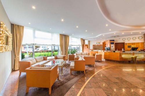 a living room with a lobby with chairs and tables at Best Western Plus Delta Park Hotel in Mannheim