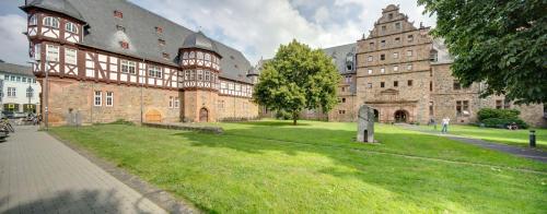 a large building with a grass yard in front of it at Best Western Plus Hotel Steinsgarten in Gießen