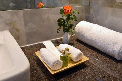 a bathroom counter with towels and a vase with a flower at Best Western Plus Delta Park Hotel in Mannheim