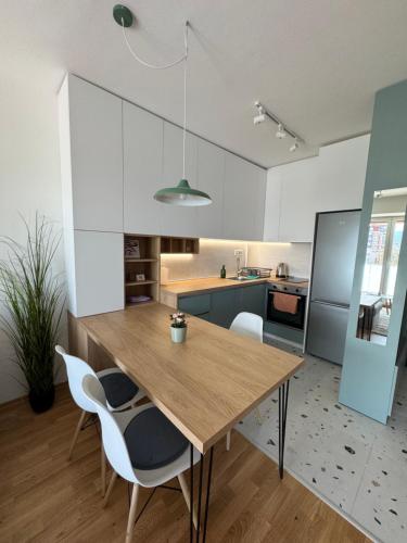 a kitchen and dining room with a wooden table and chairs at Royal Apartments in Skopje