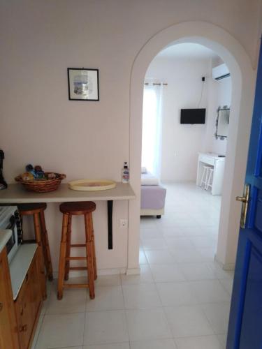 a kitchen with an archway and a table and stool at Aprilis Apartments 2 in Kiónion