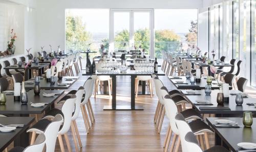 a large dining room with long tables and white chairs at Best Western Plus Atrium Hotel in Ulm