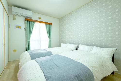 a bedroom with two beds and a window at さくらハウス - Sakura house - 広々快適 最大6名滞在可 in Tokyo