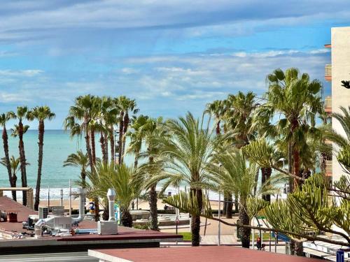 a view of a beach with palm trees and the ocean at Apartsalou Barbastre in Salou