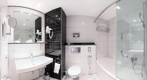 a bathroom with a toilet and a sink and a shower at Best Western Plus Palatin Kongresshotel in Wiesloch