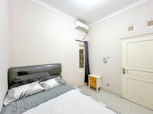 NgaglikGriya Lojajar Homestay Jogja的一间白色的卧室,配有床和门