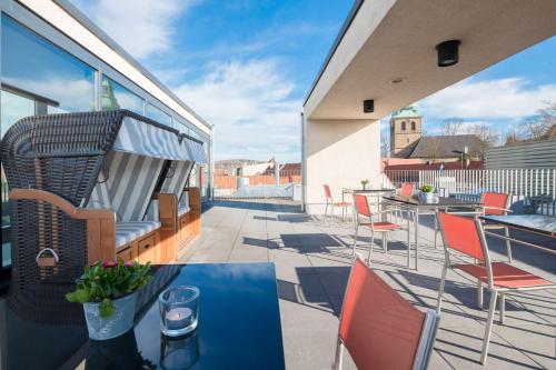 a balcony with chairs and tables on a building at Best Western Plus Hotel Ostertor in Bad Salzuflen