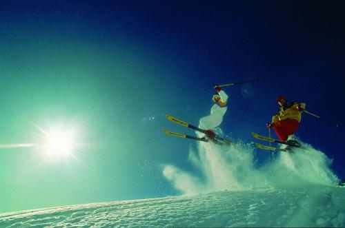 two people are skiing down a snow covered slope at Best Western Plus Hotel Willingen in Willingen