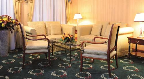 a hotel room with chairs and a table with flowers at Best Western Premier Grand Hotel Russischer Hof in Weimar