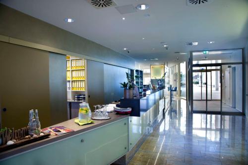 a lobby with a long counter in a building at Best Western Plus Hotel Bremerhaven in Bremerhaven