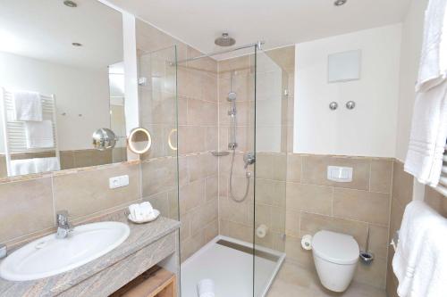 a bathroom with a shower and a sink and a toilet at Best Western Plus Hotel Alpenhof in Oberstdorf