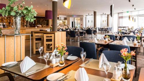 a dining room with tables and chairs in a restaurant at Best Western Plus iO Hotel in Eschborn