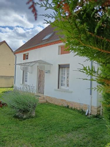 une maison blanche avec une cour devant elle dans l'établissement Le jardin caché, maison indépendante classée 3 étoiles, à Lays-sur-le-Doubs
