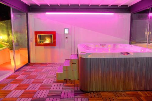 ディアーノ・マリーナにあるAppartamenti Villa il Poggioloのピンクの部屋(バスタブ、テーブル、椅子付)