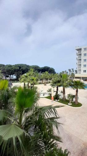 a view of a park with palm trees and a building at Vigga Apartment in Golem