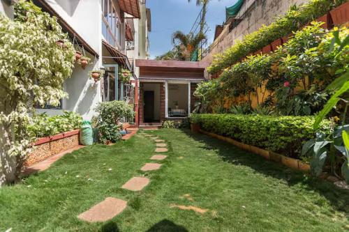 un jardin avec un chemin menant à une maison dans l'établissement Cottage like room - opp UB city, à Bangalore