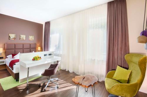 a bedroom with a bed and a desk and a chair at Best Western Hotel Hohenzollern in Osnabrück