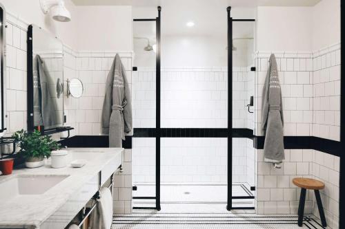 a bathroom with a shower with black and white tiles at Chicago Athletic Association, part of Hyatt in Chicago
