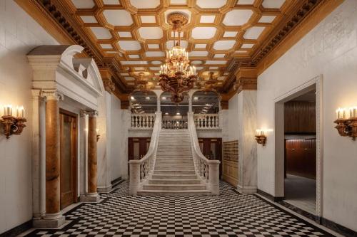 a staircase in a building with a chandelier at Chicago Athletic Association, part of Hyatt in Chicago
