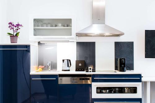 a white kitchen with blue and white cabinets at Best Western Plus Celebrity Suites in Vienna