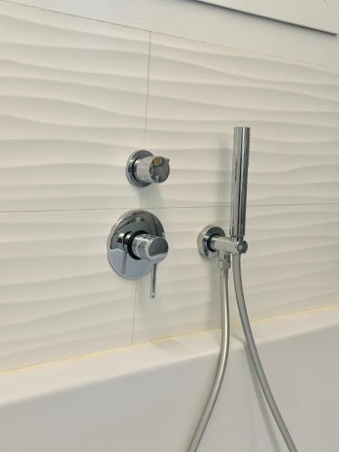 a shower head in a bathroom next to a mirror at Luxury Lake View Apartment - Lake Como - Cernobbio in Cernobbio