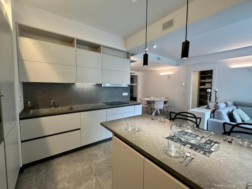a kitchen with white cabinets and a living room at Luxury Lake View Apartment - Lake Como - Cernobbio in Cernobbio