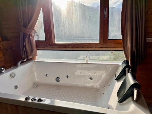 a large white bath tub in a bathroom with a window at Ahşap Tatil Evi in Çamlıhemşin