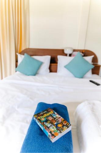a stack of books sitting on top of a bed at Mali House in Mae Nam