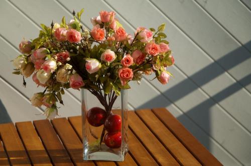 a vase with flowers and apples on a table at Ferienwohnung "Bellevue" in Sellin auf Rügen in Ostseebad Sellin