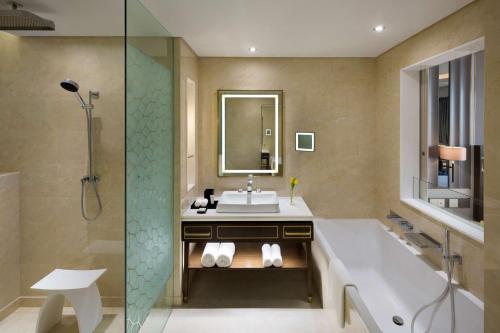 a bathroom with a tub and a sink and a shower at Grand Hyatt Al Khobar Hotel and Residences in Al Khobar