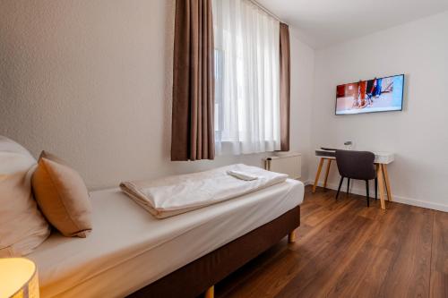 a bedroom with a bed with a window and a table at Hotel Winterberg Resort in Winterberg