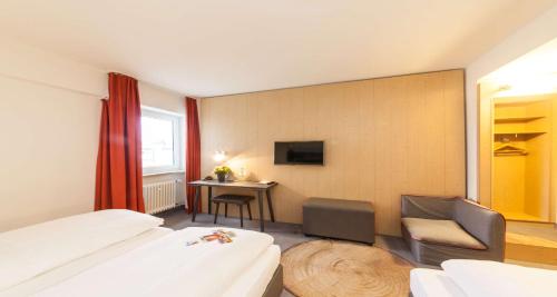 a hotel room with a bed and a chair and a desk at Sure Hotel by Best Western Muenchen Hauptbahnhof in Munich