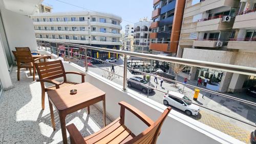 un balcon avec des chaises et une table et une vue sur une ville dans l'établissement The Colors of Larnaca, à Larnaka