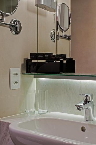 a bathroom sink with two glasses and a mirror at Hotel Atlantico Prime in Rio de Janeiro