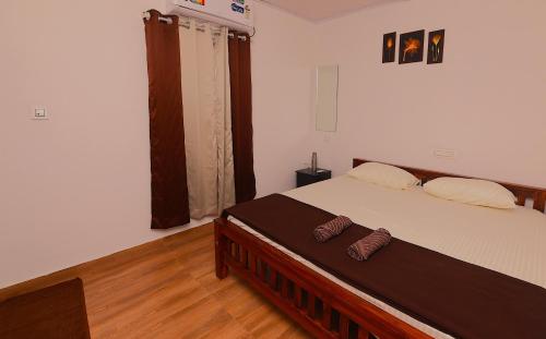 a bedroom with a large bed with a wooden floor at Third Eye Homestay in Cochin
