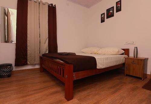 a bedroom with a bed with a wooden frame at Third Eye Homestay in Cochin
